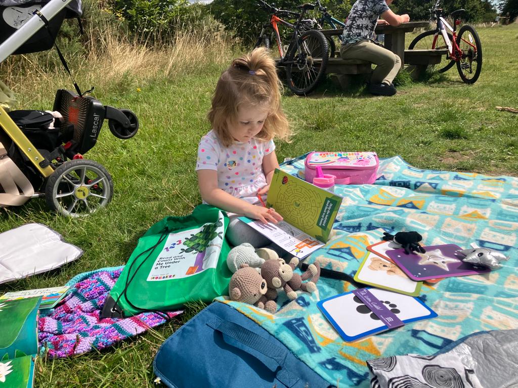 Image of a little girl enjoying the Read Under a Tree bags. These can be borrowed from Essex County Parks.